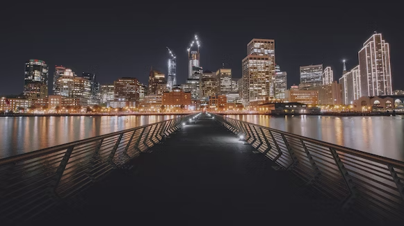 Pier 14 at night, looking towards downtown San Francisco's brightly lit buildings